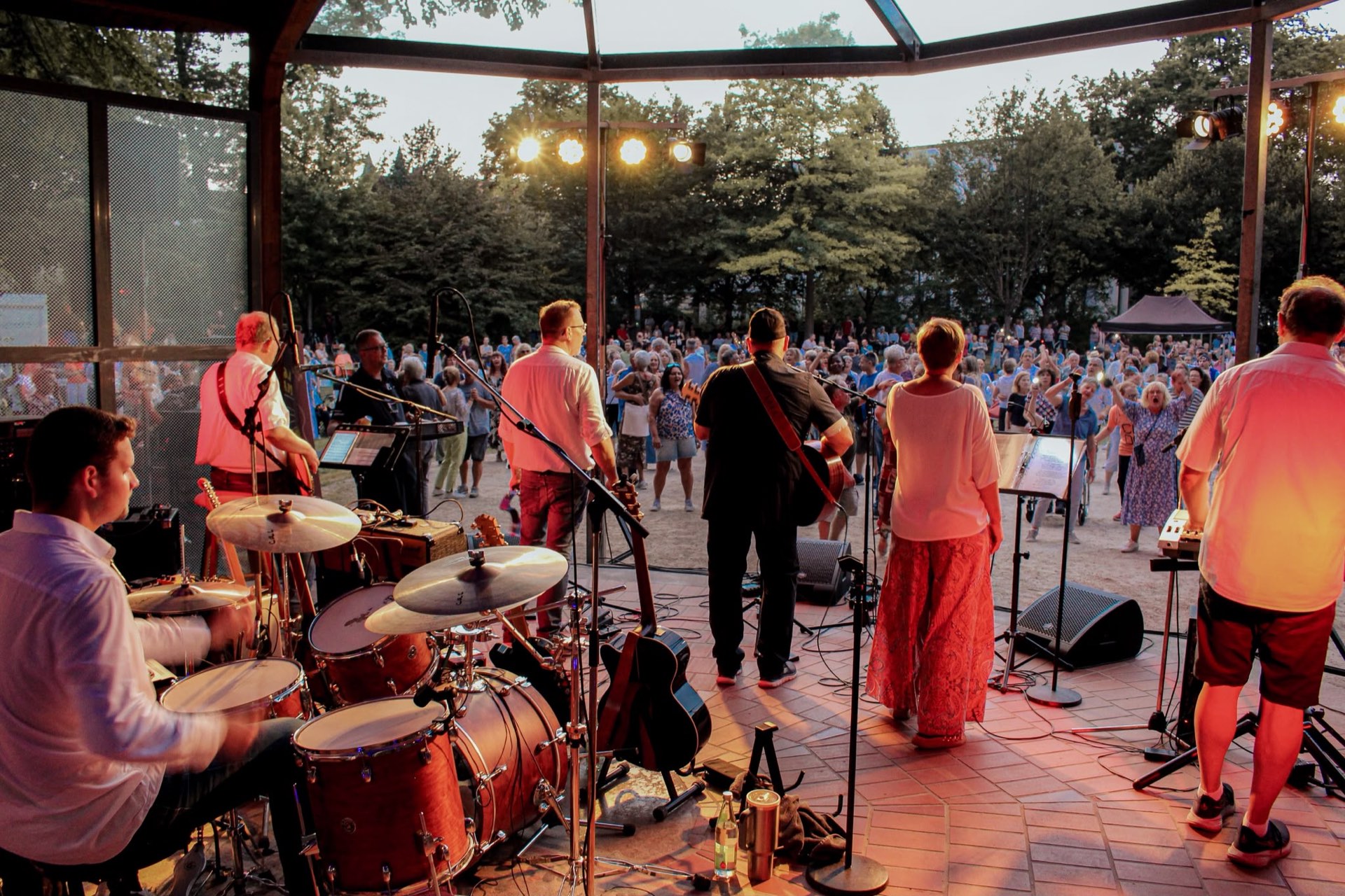 Lower Market live auf der Bühne im Max-Reger-Park — Blick über die Band ins tanzende Publikum bei Abendlicht
